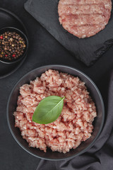 Raw minced meat in bowl on black table