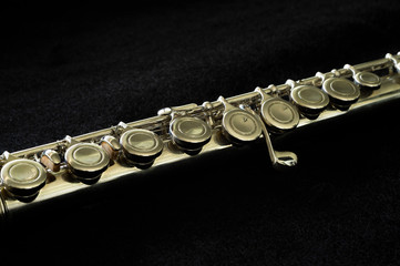 silver flute close-up on black background, short depth of field.