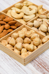 Close-up of hazelnuts nuts in a wooden box. Assortment of nuts in the background.