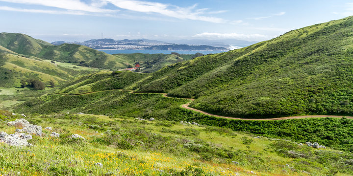 Spring Stroll - The Miwok Trail leads down a valley, with the Golden Gate and San Francisco in the distance. Marin Headlands, California, USA