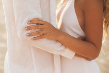 Hands of hugging couple.