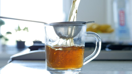 Image with Making a Hot and Aromatic Tea Using a Strainer and Natural Tea Leafs