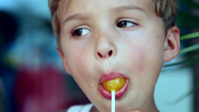 Toddler child with lolipop in mouth face portrait