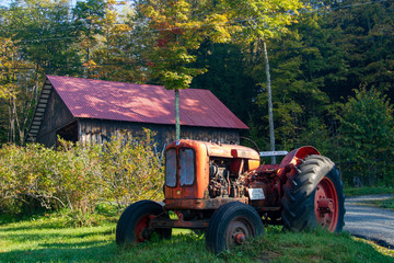 Vintage tractor in front  of an old barn