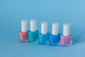 multi-colored nail polish on a blue background.