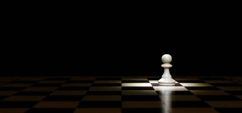 a lone pawn on a chessboard