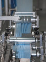 section of the automatic line for the production of protective masks made of spandbond, the material is laid in three folds