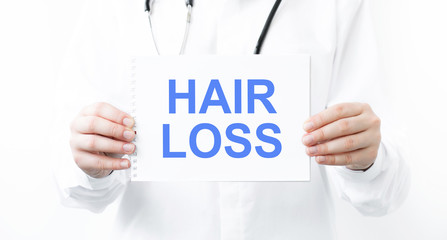 Doctor holding a card with text Hair Loss, medical concept.