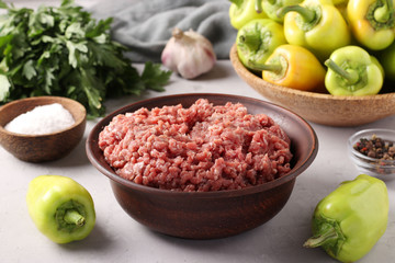 Minced beef meat, organic bell peppers, parsley and spices for making stuffed peppers.