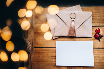 Blank white paper with dry flower on a wooden desk and boke in the background