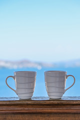 two coffee cup coffee cups in wooden balcony terrace with sea view