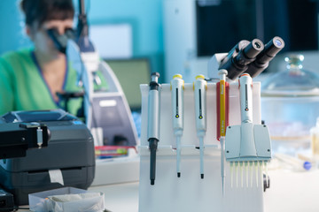 Female professional in uniform. Work with a light microscope in a research laboratory, testing...