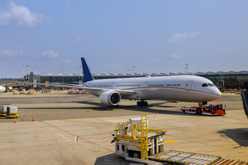Passenger plane at airport view with airplanes and service vehicles near boarding terminal