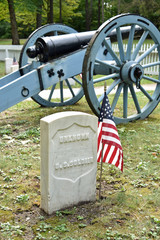 A cannon and grave marker for the unknown soldier at Post cemetery, Fort Mackinac, Mackinac Island
