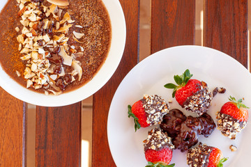 Breakfast bowl with quinoa, banana, coconut, cocoa, walnuts served on wooden table