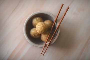 Vietnamese donuts called as Banh Ran. They are made from rice flour, mashed potato, sugar, mashed mung beans and sesame. Traditional cake of Vietnam. Flat lay, top view.