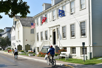 Bike riders on a town street, exploring Mackinac Island