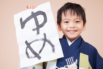 書き初めを持って笑う男の子