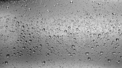 drops of water on grey surface in black and white