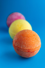 bath bombs in a row. pink, yellow, orange colors. spa and relaxation concept. vertical photo.