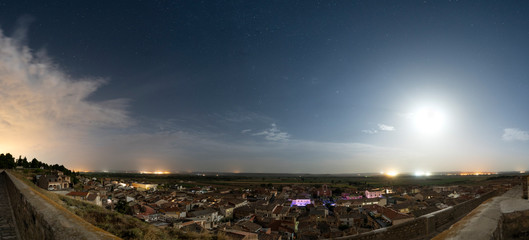 Panoramica de pueblo en noche con luna de fondo