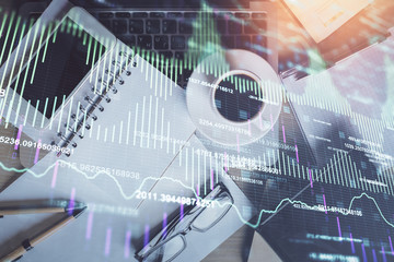 Double exposure of financial graph hologram over desktop with phone. Top view. Mobile trade platform concept.