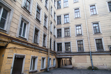 Fototapeta premium The courtyard of an old apartment building in St. Petersburg with yellow shabby walls