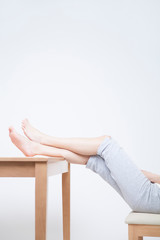 Obraz premium テーブルに足を乗せる女性