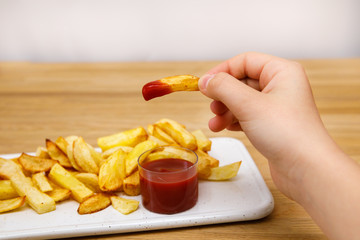 Fresh french fries with ketchup on a white rectangular plate
