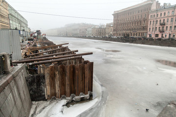 Overhaul of the Fontanka river embankment in winter. Strengthening the coast