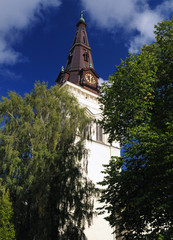 Fototapeta na wymiar Clock Tower Of Domkyrka Cathedral In Karlstad On A Sunny Summer Day With A Clear Blue Sky