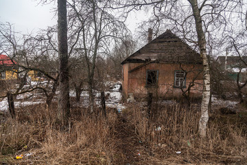abandoned dilapidated village house in winter forest