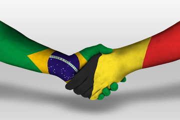 Handshake between belgium and brazil flags painted on hands, illustration with clipping path.