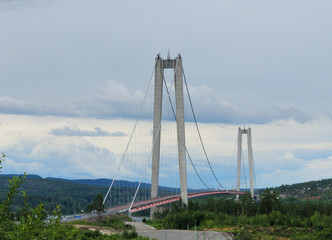 Fototapeta premium Suspension Bridge Hoga Kustenbron Over Angermanalven On A Cloudy Summer Day