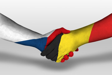 Handshake between belgium and czech republic flags painted on hands, illustration with clipping...