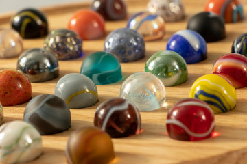 A closeup with shallow depth of field of a Venetian Marble Solitaire board. 