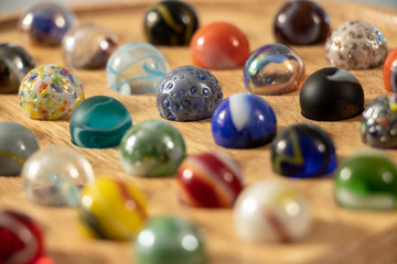 A closeup with shallow depth of field of a Venetian Marble Solitaire board. 