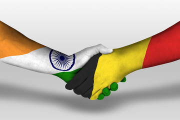 Handshake between belgium and india flags painted on hands, illustration with clipping path.