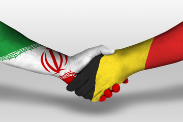 Handshake between belgium and iran flags painted on hands, illustration with clipping path.