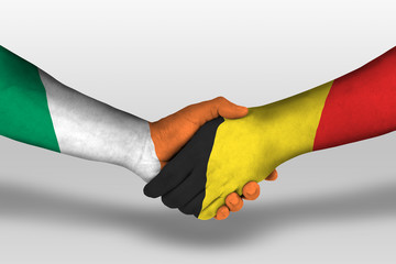 Handshake between belgium and ireland flags painted on hands, illustration with clipping path.