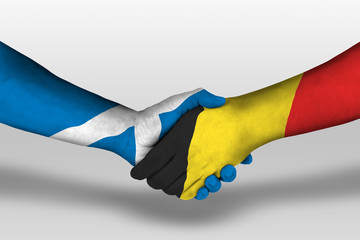 Handshake between belgium and scotland flags painted on hands, illustration with clipping path.