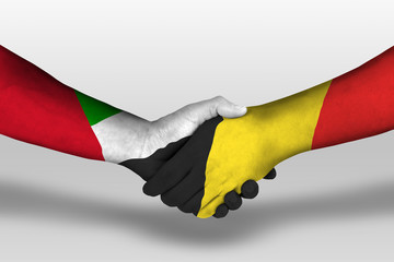 Handshake between belgium and united arab emirates flags painted on hands, illustration with...