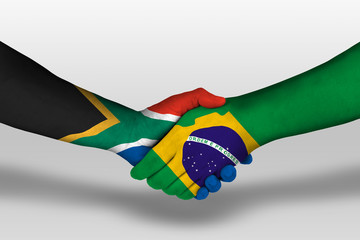 Handshake between brazil and south africa flags painted on hands, illustration with clipping path.