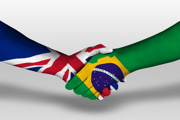Handshake between brazil and united kingdom flags painted on hands, illustration with clipping path.