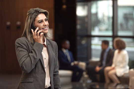 Executiva latina falando ao celular.