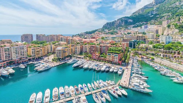 4K timelapse / hyperlapse of the cityscape and harbor of Monte Carlo or Port de Fontvieille, Monaco, Principality of Monaco in a cloudy and sunny summer day