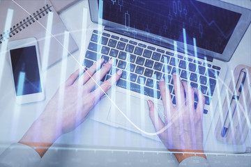 Double exposure of woman hands working on computer and forex graph hologram drawing. Top View. Financial analysis concept.