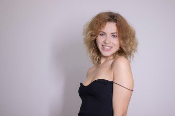 Fototapeta premium emotional portrait of a beautiful curly blonde-redhead in black undershirt. High quality photo