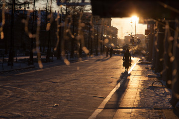 Silhouettes of people on a winter street in ice