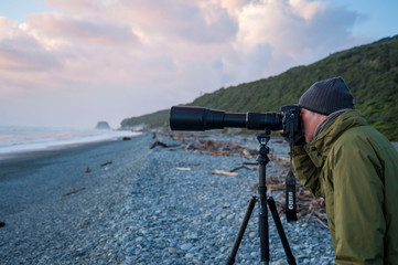 ニュージーランド、南島、ポイントエリザベスの夕景の写真を撮るかっこいいアクティブシニア
